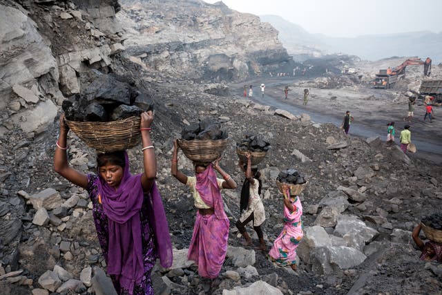 <p>Girls collect coal from a mine in Dhanbad, India, in 2019</p>