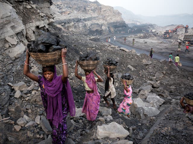 <p>Girls collect coal from a mine in Dhanbad, India, in 2019</p>