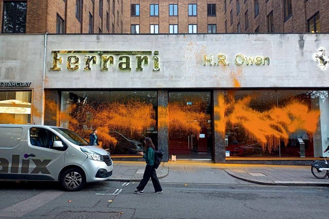 Just Stop Oil protesters spray paint a Ferrari car showroom on Berkley Square in central London (PA)