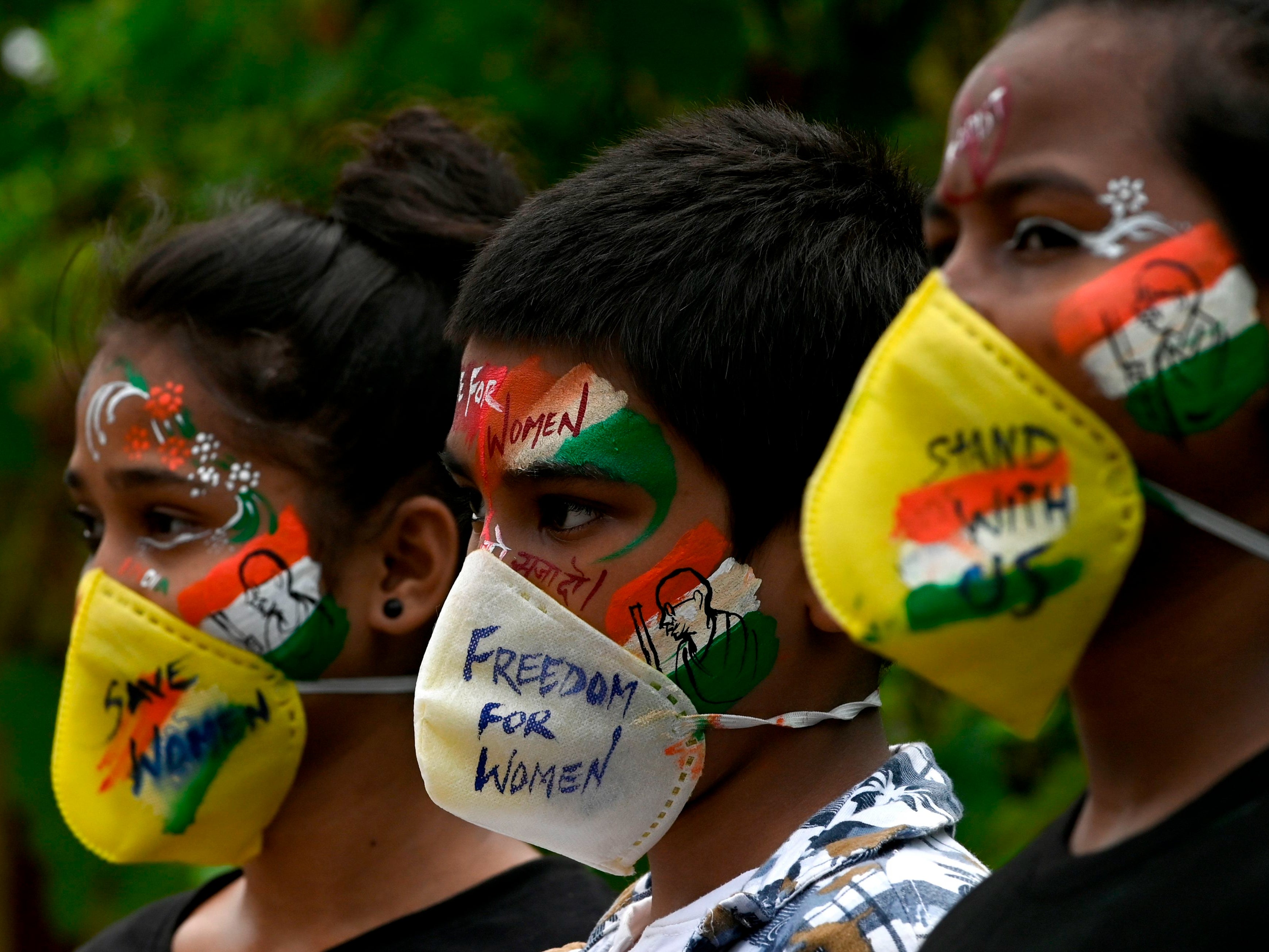 (FILE) Students look on after getting their face painted to condemn the gang-rape of a 19-year-old woman victim in Mumbai