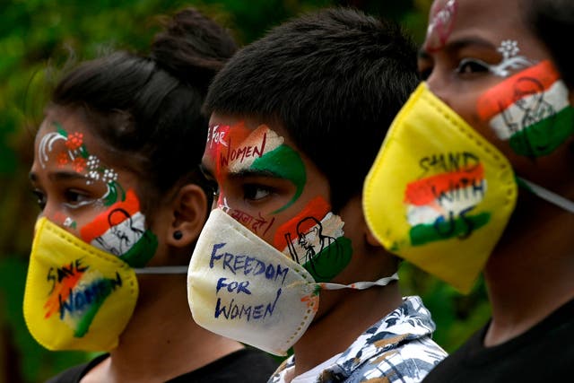 <p>Students look on after getting their face painted to condemn the gang-rape of a  19-year-old woman victim by four men in Bool Garhi village of Uttar Pradesh state, in Mumbai on 2 October 2020</p>