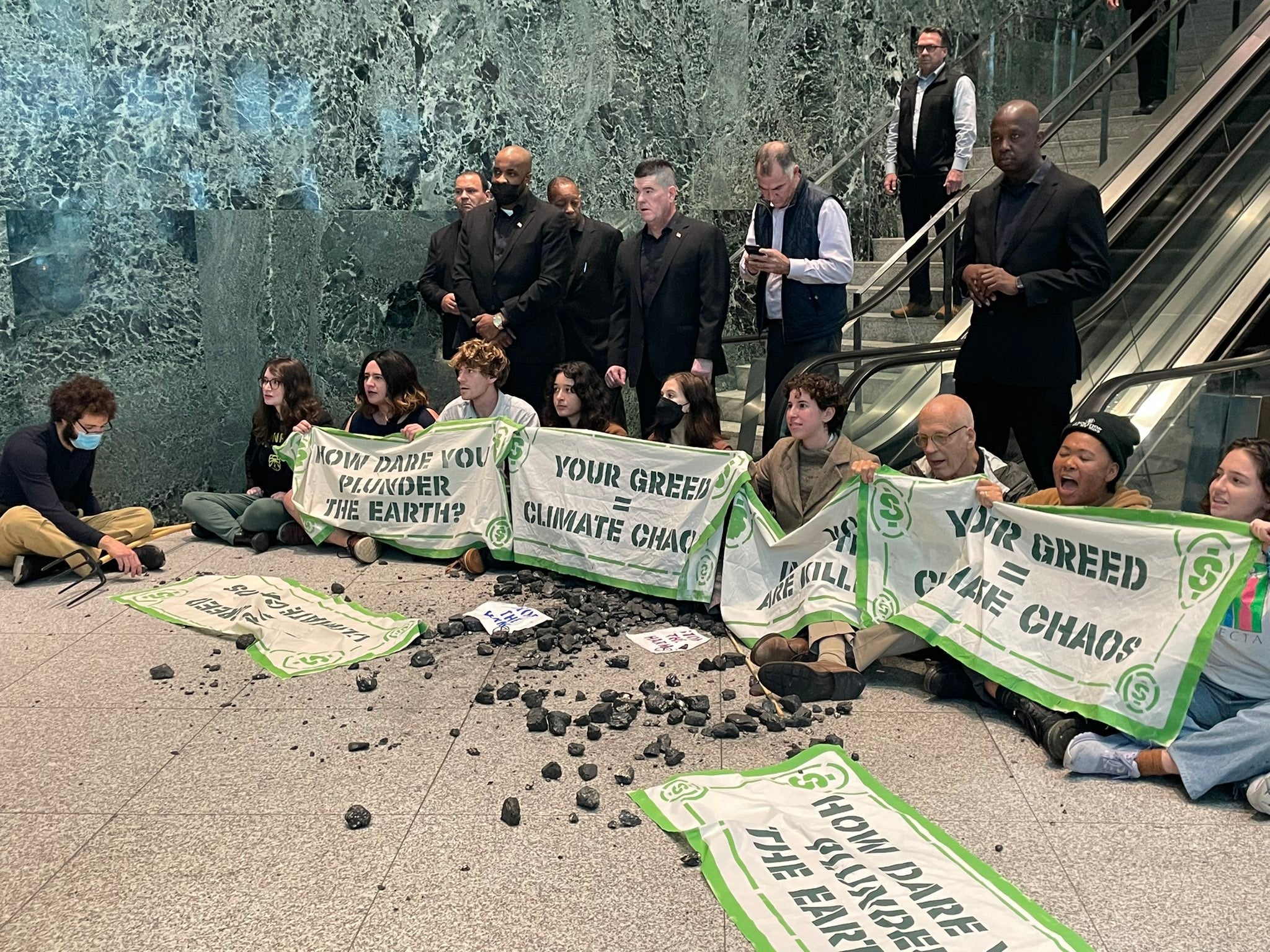 <p>Activists sit down in front of BlackRock’s escalators in New York on Wednesday</p>