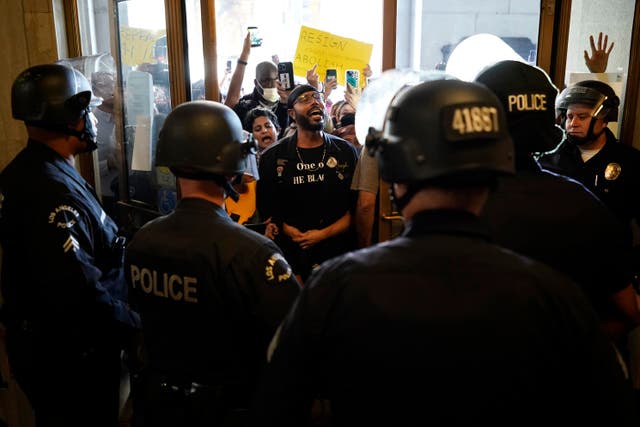 <p>Protesters chant a slogan as they face off with police at the entrance of the Los Angeles City Hall in Los Angeles, Tuesday, Oct. 18, 2022.</p>