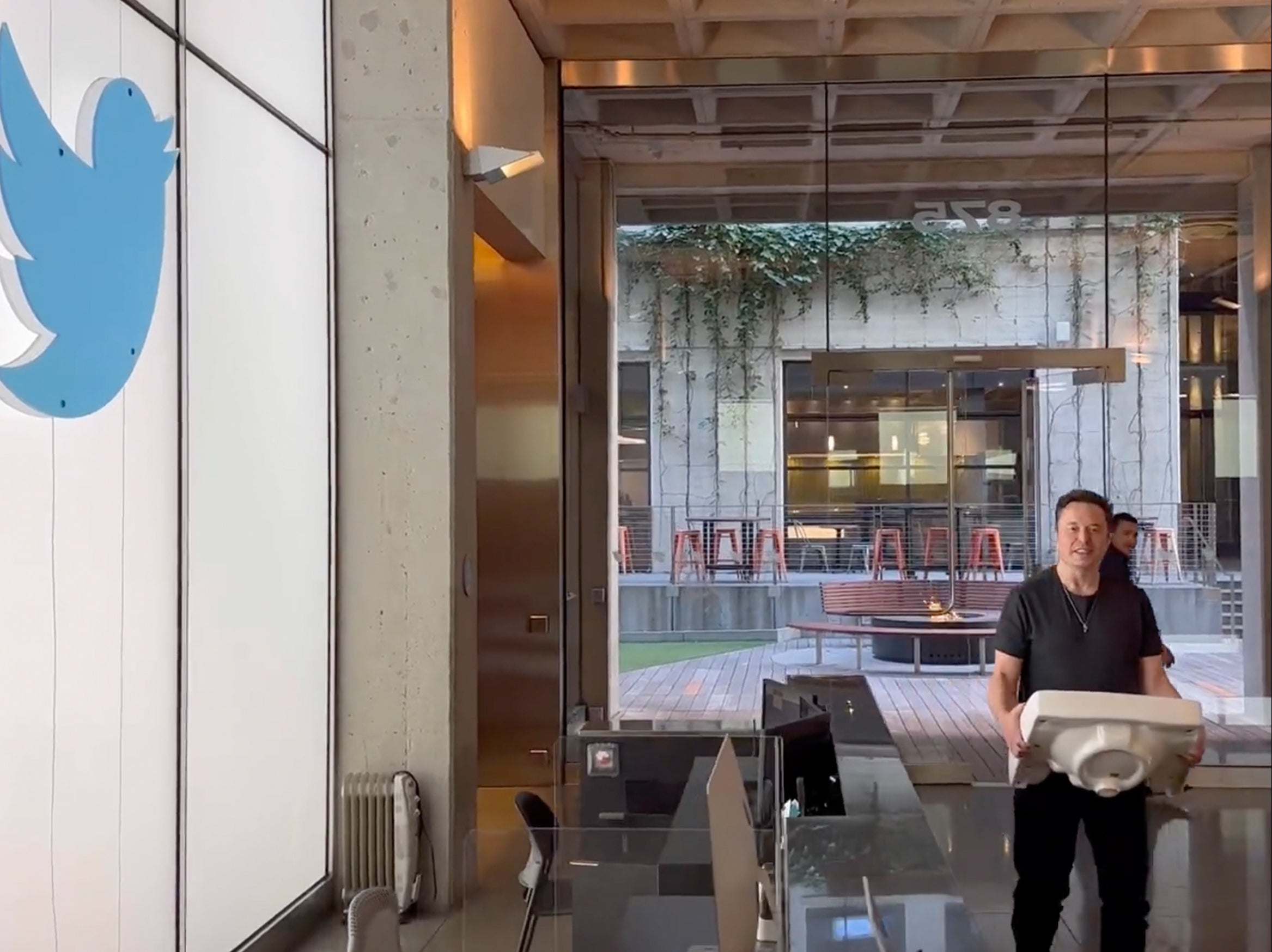 Elon Musk enters Twitter headquarters carrying a sink