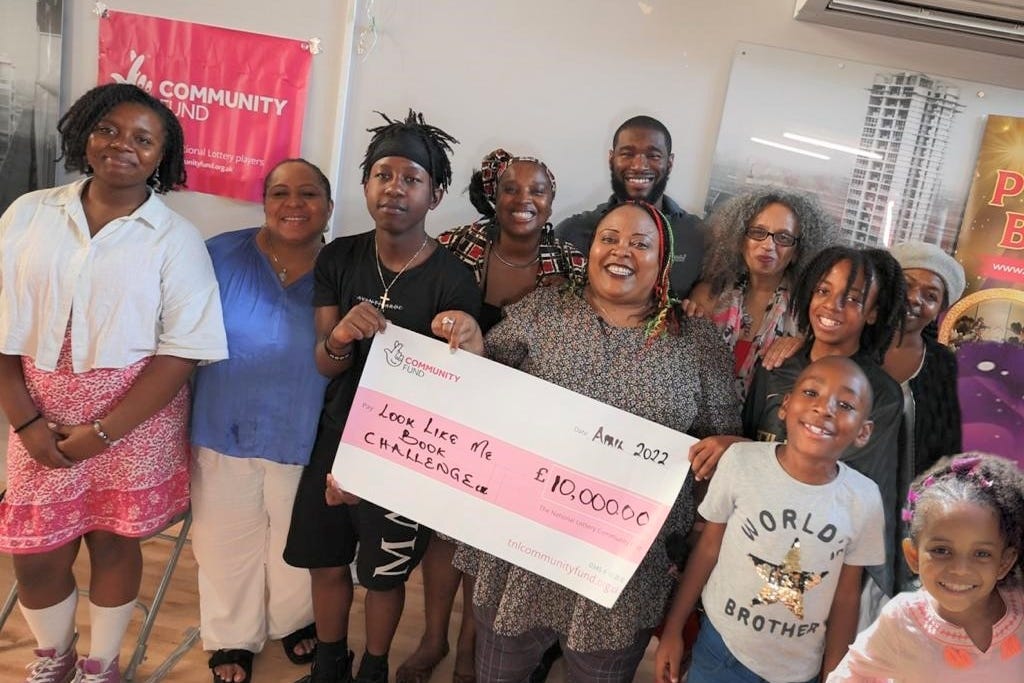 Members of the ‘Look Like Me Book Challenge CIC’ holding a cheque they were awarded by the National Lottery to improve Black representation in children’s books, with Winsome Duncan in the middle (Look Like Me Book Challenge CIC)