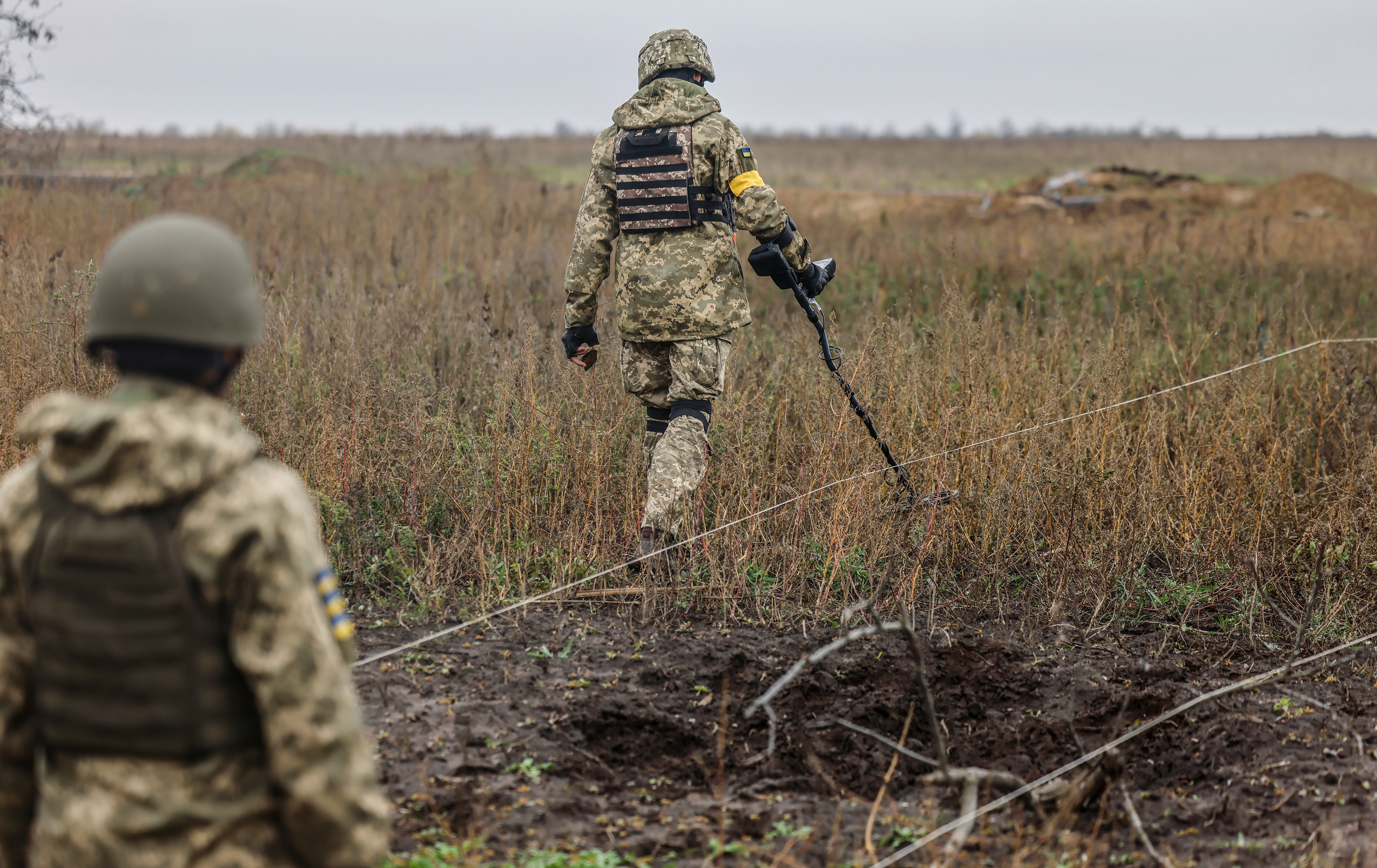 Ukrainian soldiers search for explosives at a recaptured area in the north of Kherson