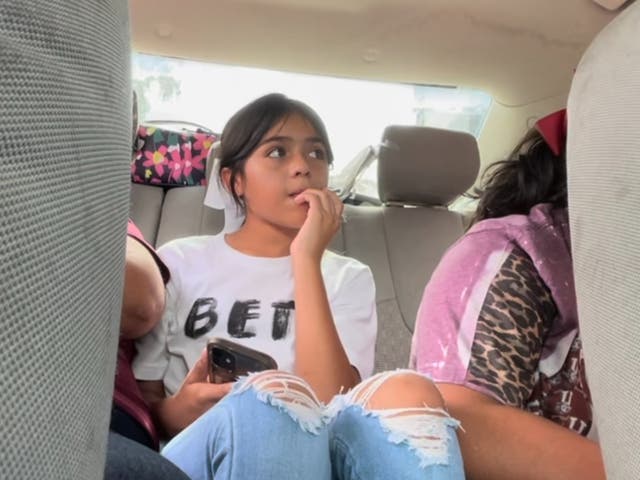 <p>Caitlyne Gonzalez sits in the backseat of her parents' car </p>