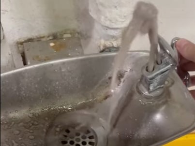Grey, murky water flowing from a drinking fountain aboard the US Navy aircraft carrier USS Abraham Lincoln. The Navy confirmed the water had been contaminated with both E Coli and bilgewater