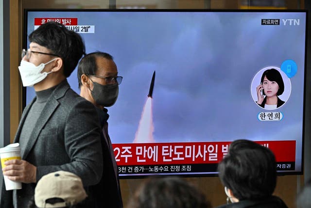 <p>People watch a television screen showing a news broadcast with file footage of a North Korean missile test, at a railway station in Seoul on 28 October, after North Korea fired two short-range ballistic missiles according to South Korea's military</p>