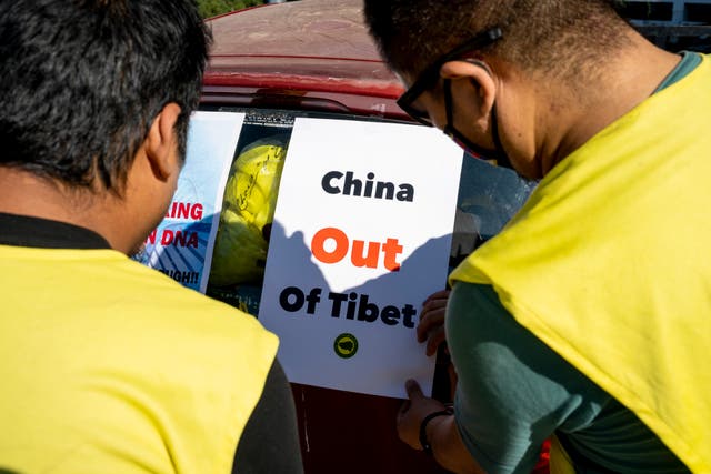 <p>Exiled Tibetans put up posters on a vehicle against China</p>