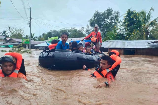 <p>his handout photo taken and released by the Philippine Coast Guard on 28 October 2022 shows rescue workers evacuating people from a flooded area due to heavy rain brought by Tropical Storm Nalgae in Parang, Maguindanao province</p>