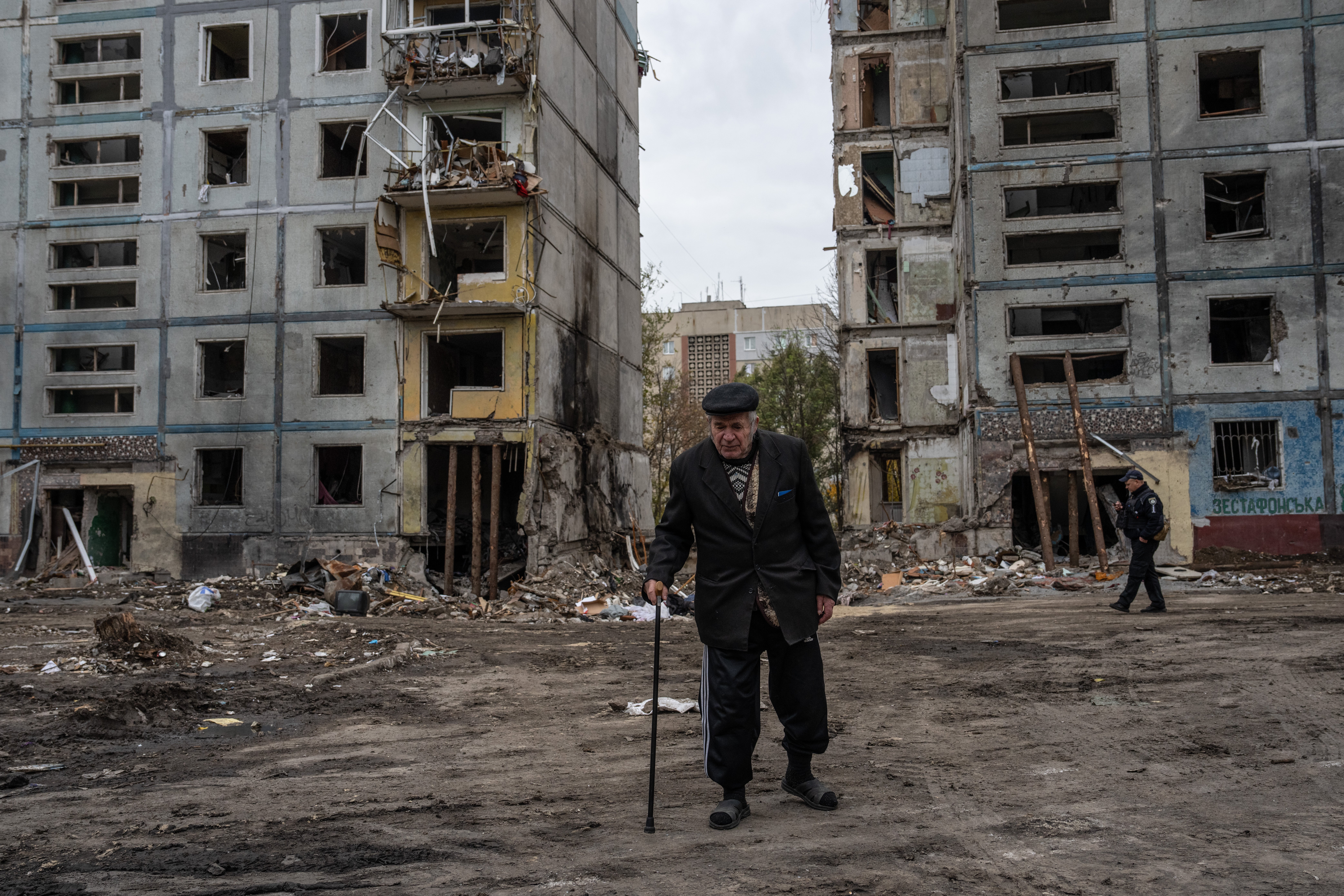 An elderly man walks by an apartment block destroyed by a Russian missile in Zaporizhzhia