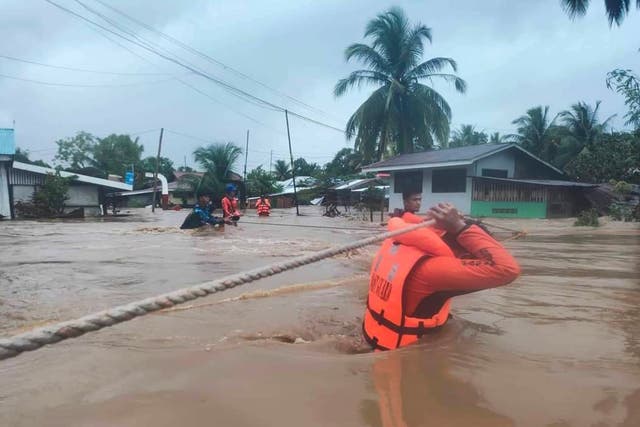 <p>The Philippine Coast Guard rescuers use ropes as they evacuate residents from flooded areas due to Tropical Storm Nalgae</p>