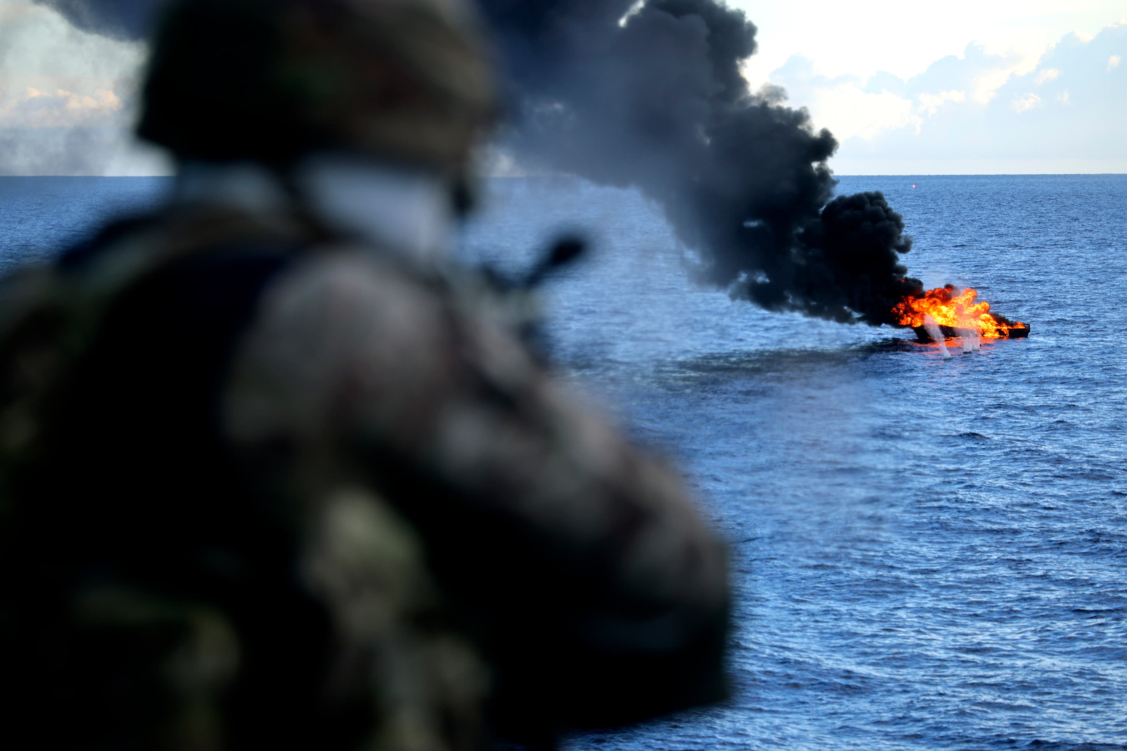 A Royal Navy sailor takes aim at the target of interest following a drugs bust off the Caribbean (Royal Navy/PA)