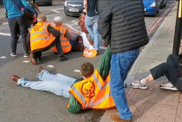 Screengrab from a video posted by Just Stop Oil of one of their activists being dragged off the street in south London (Just Stop Oil)