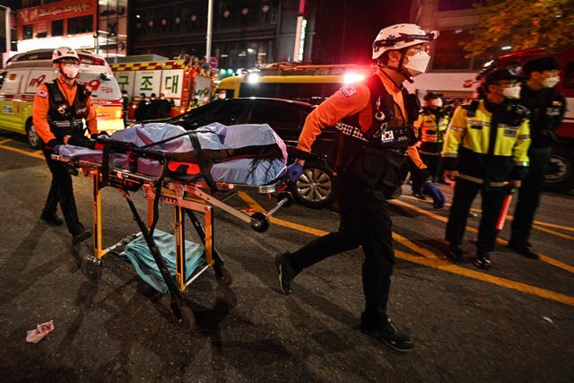 <p>The body of a victim of a Halloween crush, which left at least 154 people dead, is transported on a stretcher in the district of Itaewon</p>