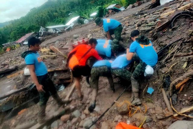 <p>Rescuers retrieve bodies during the search and rescue operations due to landslides caused by tropical storm Nalgae</p>