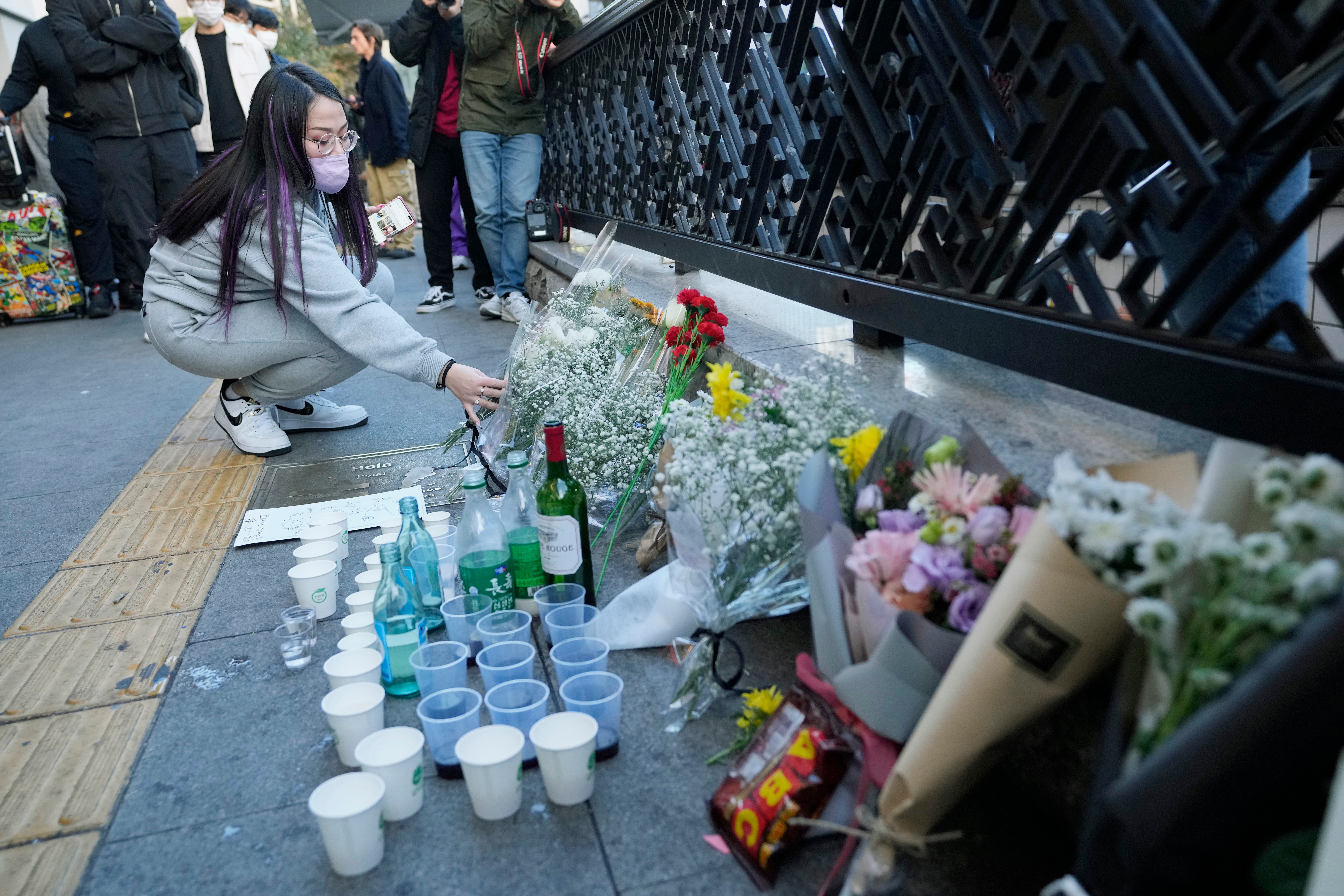 A woman places flowers in tribute to the victims near the scene of the incident in Seoul, South Korea (Ahn Young-joon/AP)