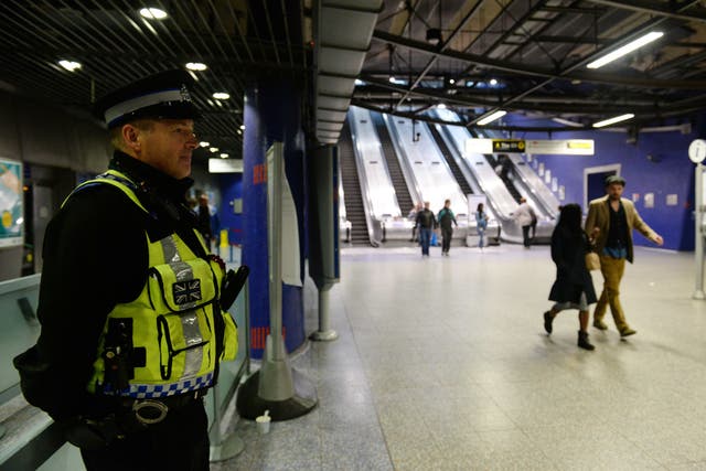 A police officer stands in the entrance hall to North Greenwich underground station (PA)
