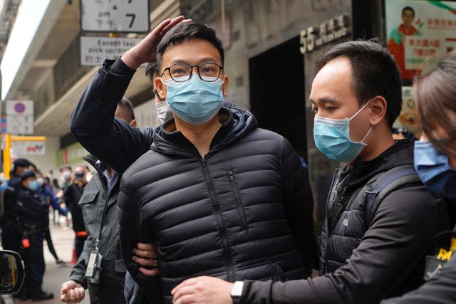 <p>Patrick Lam (centre), editor of Stand News, is arrested by police officers after they searched his Hong Kong office on 29 December 2021</p>