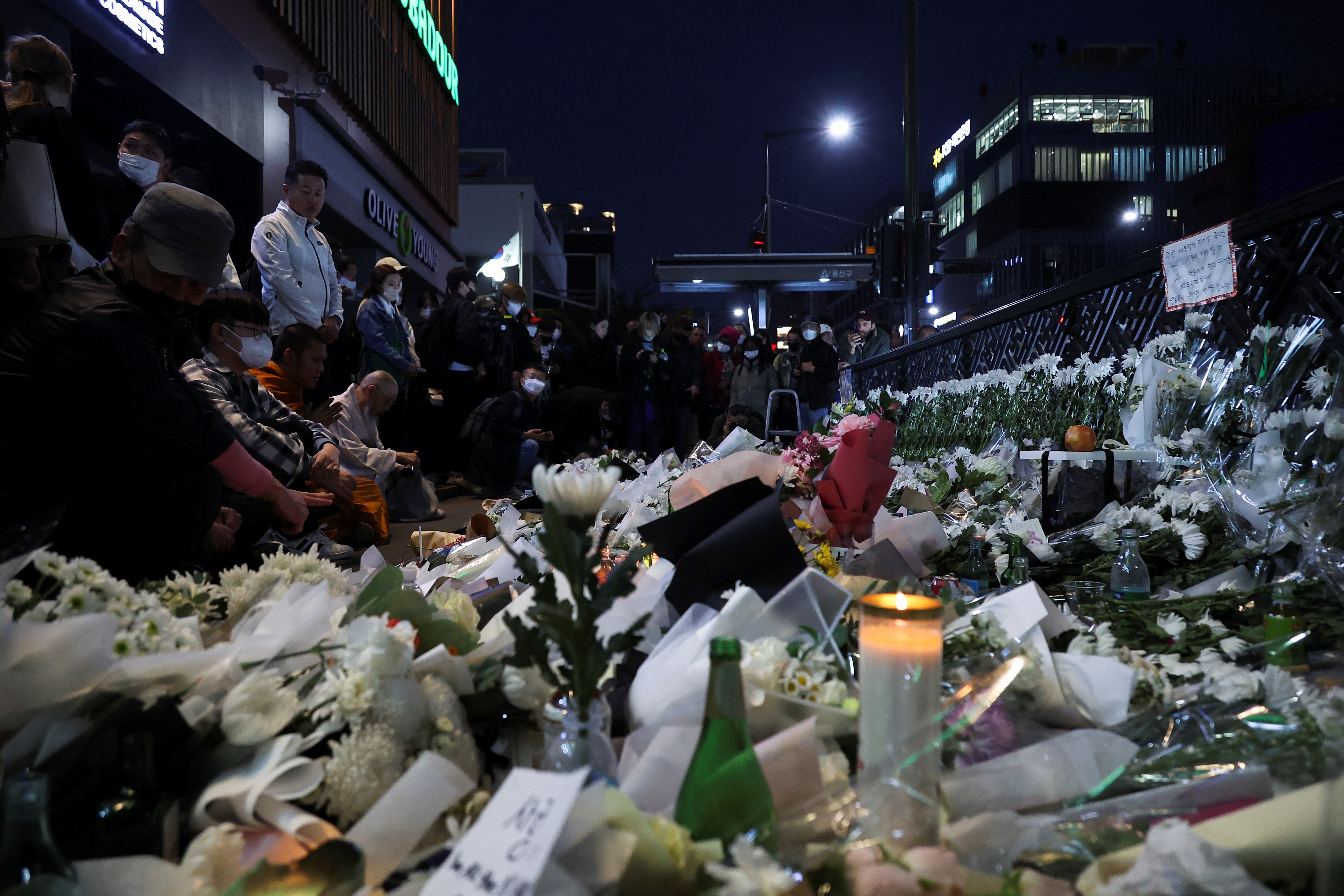People pay their respects near the scene of the Halloween stampede