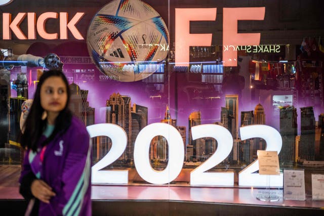 <p>A woman walks past a store in a mall in Doha on October 29, 2022, ahead of the Qatar 2022 FIFA World Cup football tournament</p>