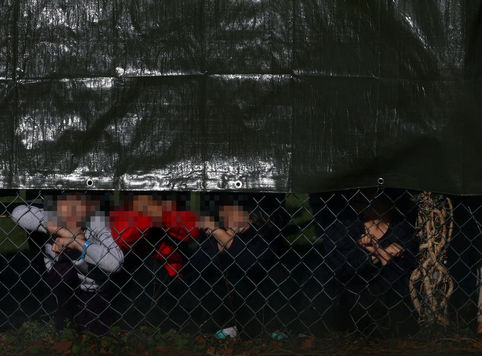 Child detainees look out a fence at Manston