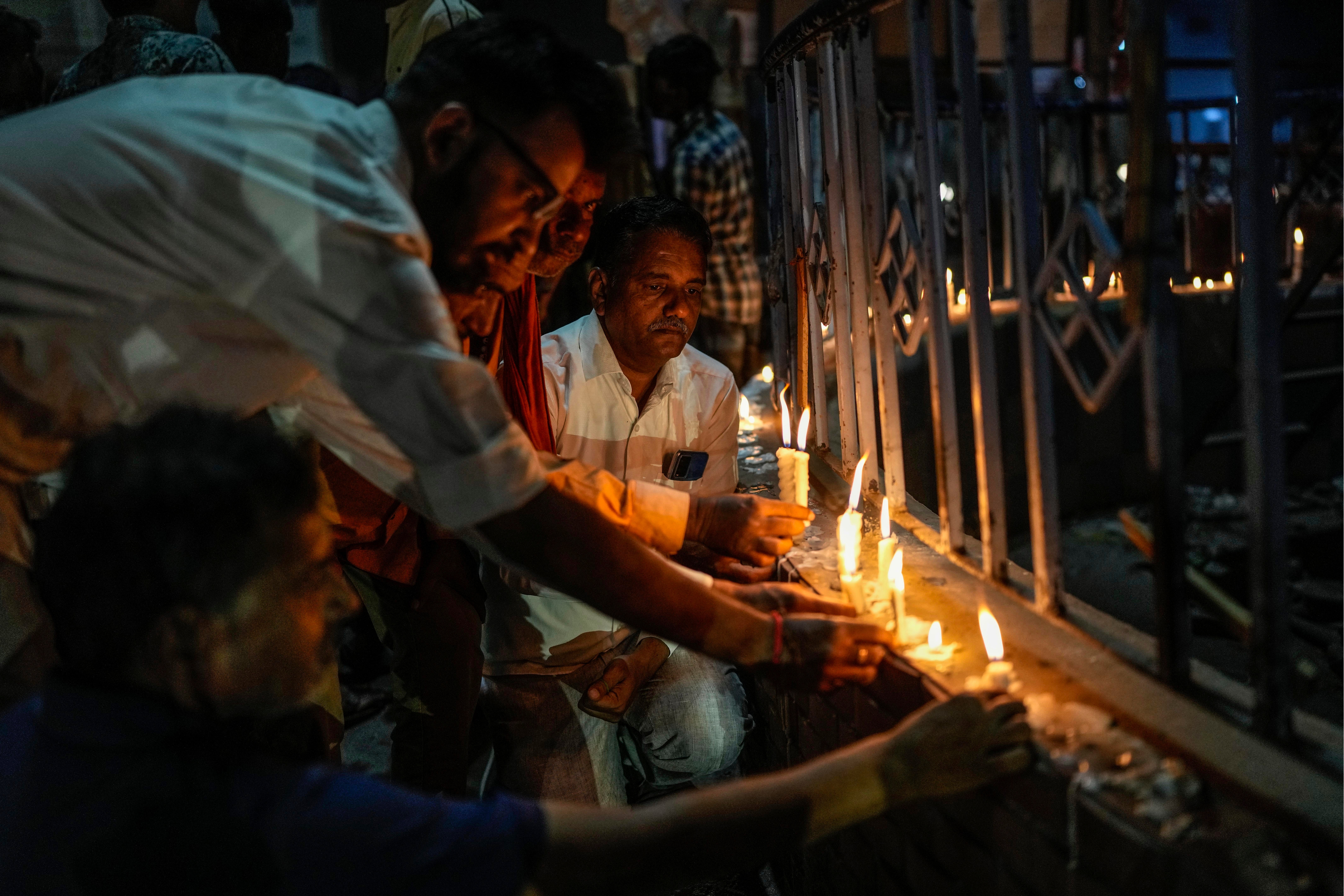 People light candles to pay tribute to victims of Sunday’s bridge collapse in Morbi