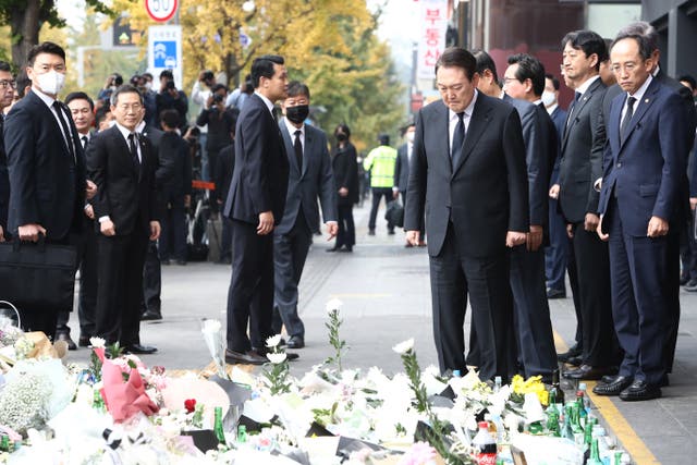 <p>South Korean president Yoon Suk-yeol and cabinet members pay tribute to the victims of the Halloween celebration stampede, on the street near the scene on 1 November 2022 in Seoul, South Korea</p>