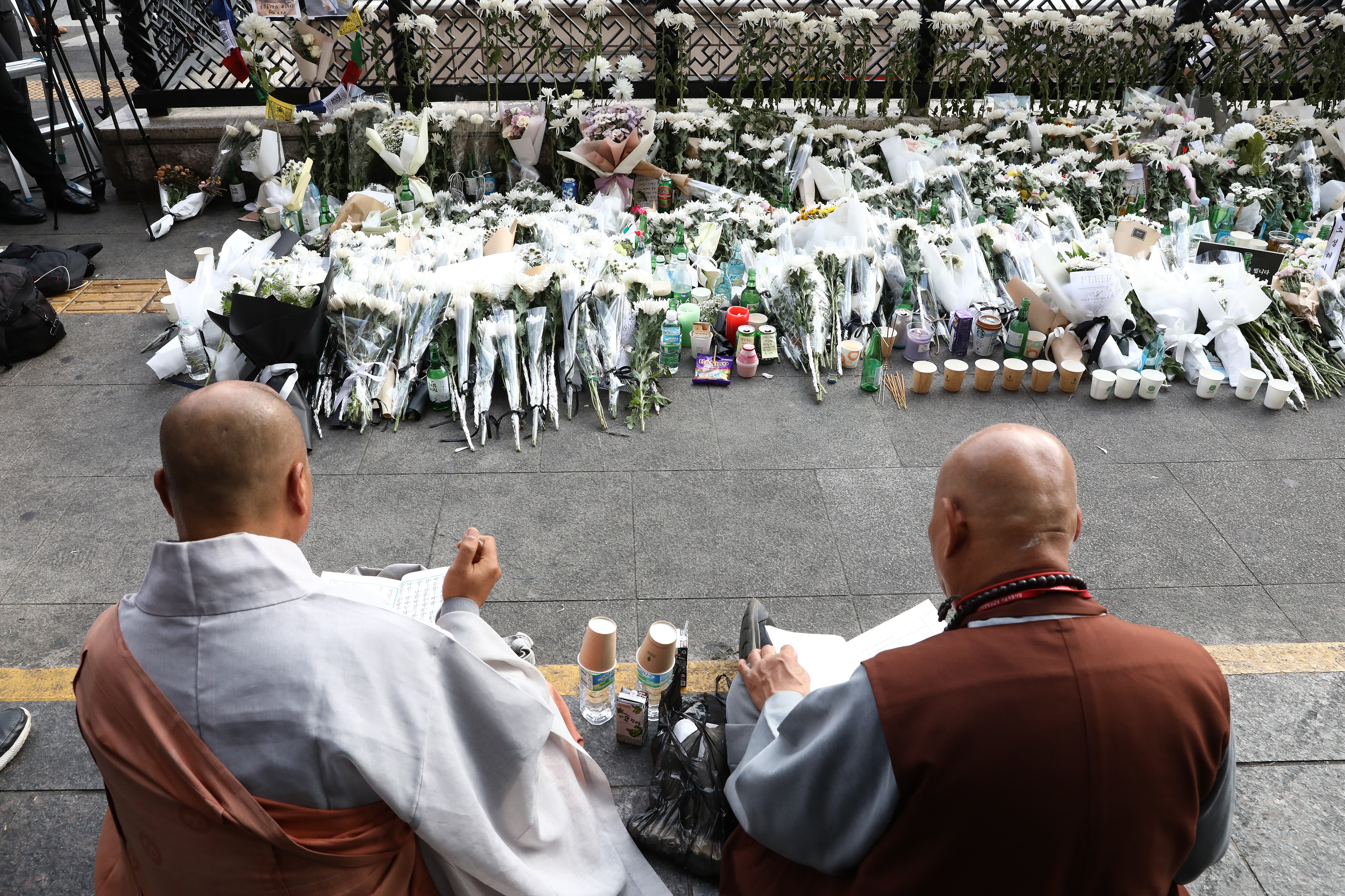 Monks pay tribute for the victims of the Halloween celebration stampede, on the street near the scene on 31 October 2022 in Seoul, South Korea