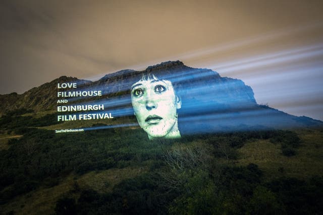 An image of actor Anna Karina from the film Vivre Sa Vie projected on Salisbury Crags in Edinburgh (Jane Barlow/PA)