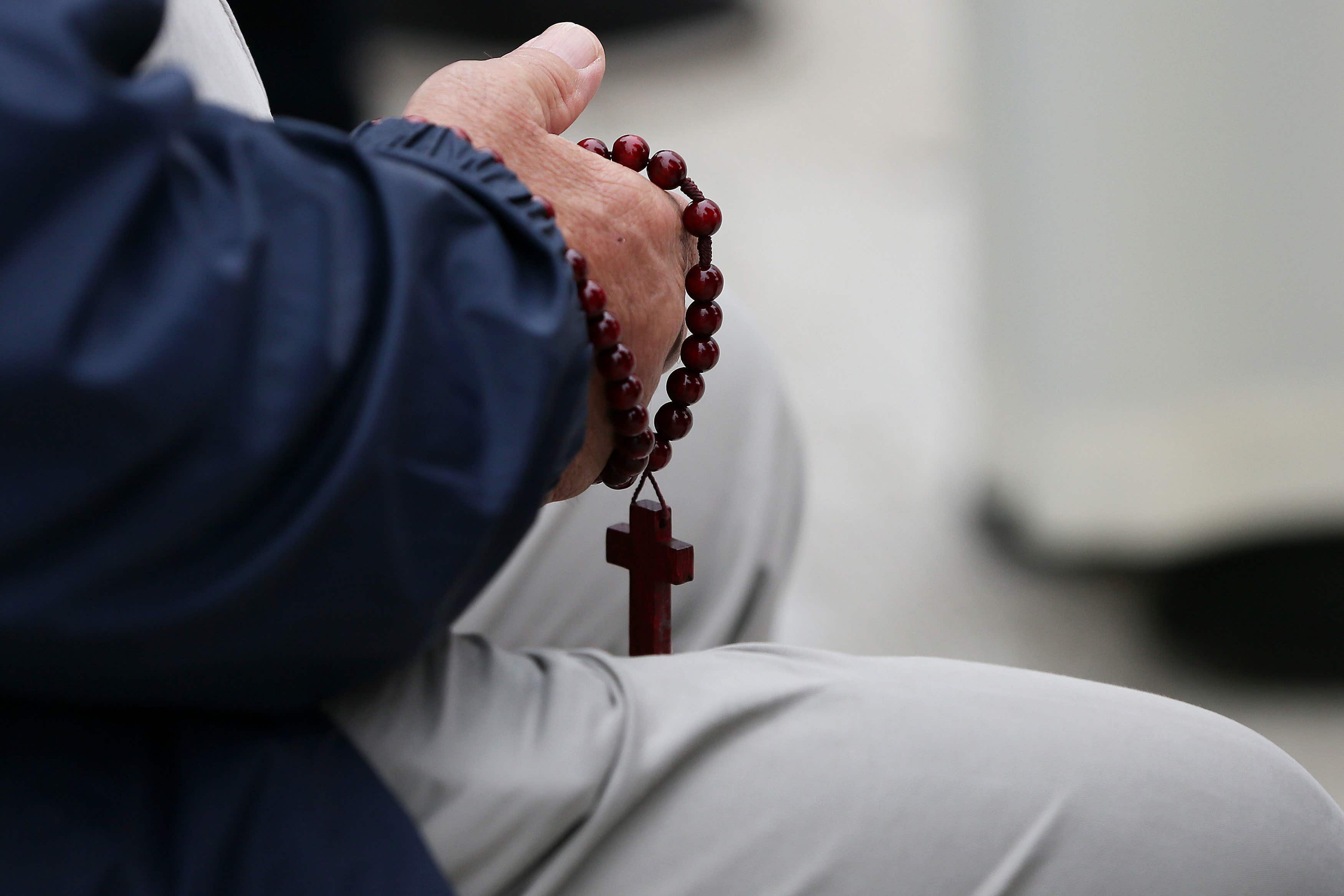 File photo of a man holding rosary beads (Brian Lawless/PA)