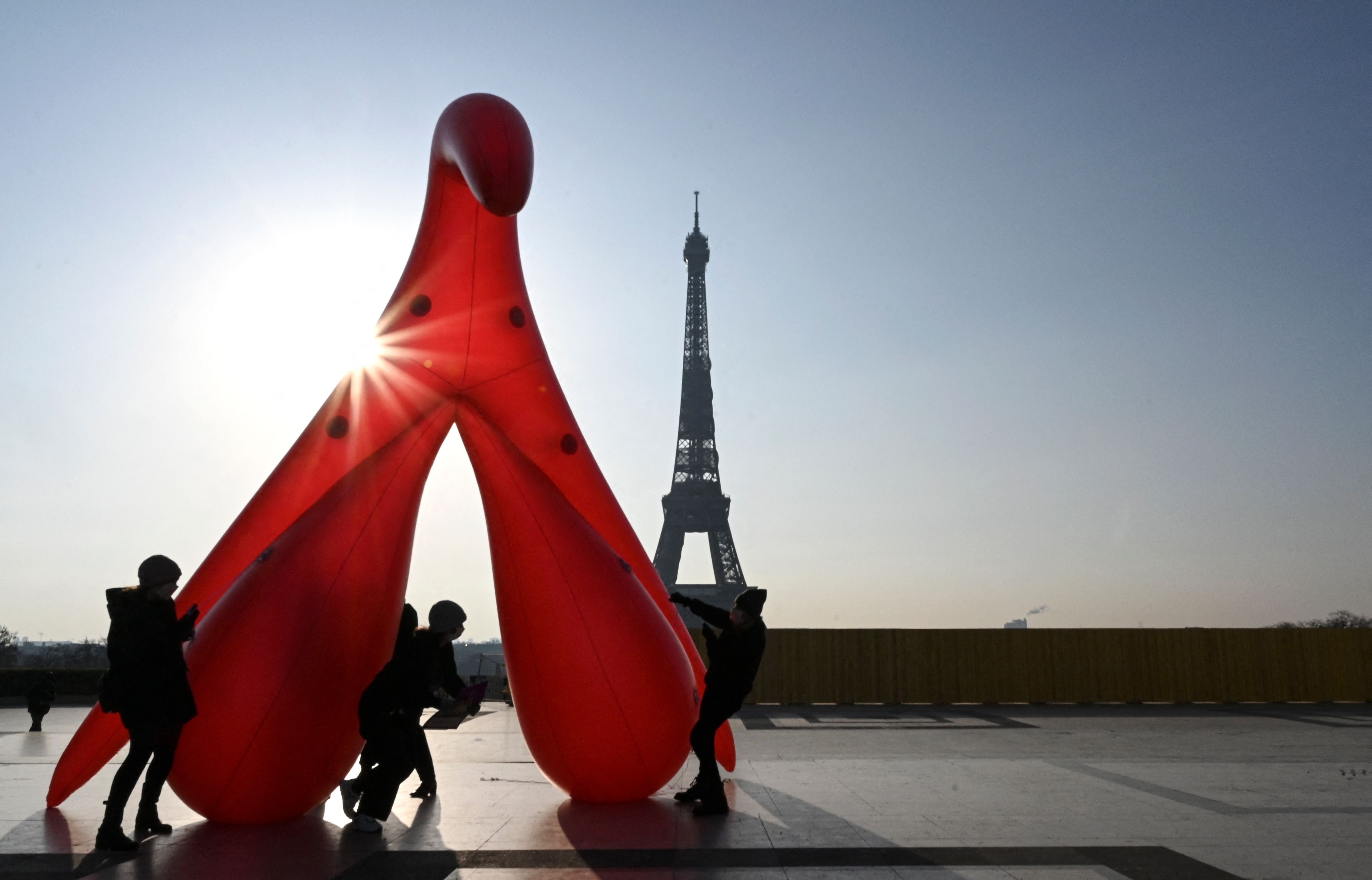 <p>Members of the group ‘Gang du Clito’ carry a five-metre-high inflatable clitoris to denounce sexual illiteracy to mark International Women’s Day on 8 March 2021</p>