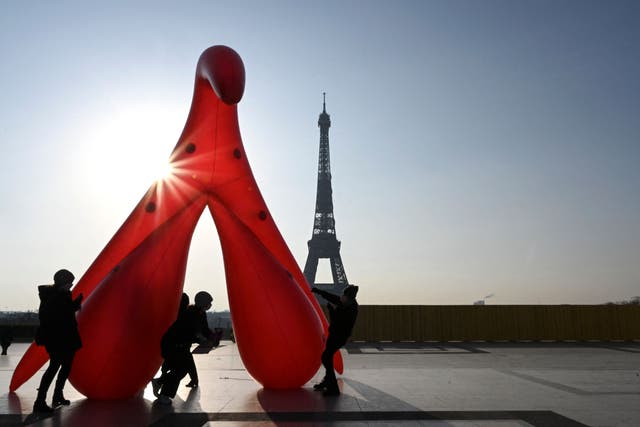 <p>Members of the group ‘Gang du Clito’ carry a five-metre-high inflatable clitoris to denounce sexual illiteracy to mark International Women’s Day on 8 March 2021</p>