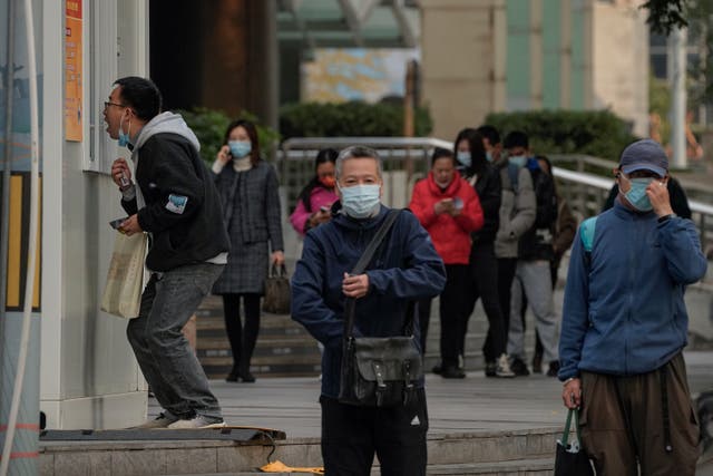<p>Residents line up to get their routine COVID-19 throat swabs at a coronavirus testing site setup along a pedestrian walkway in Beijing</p>