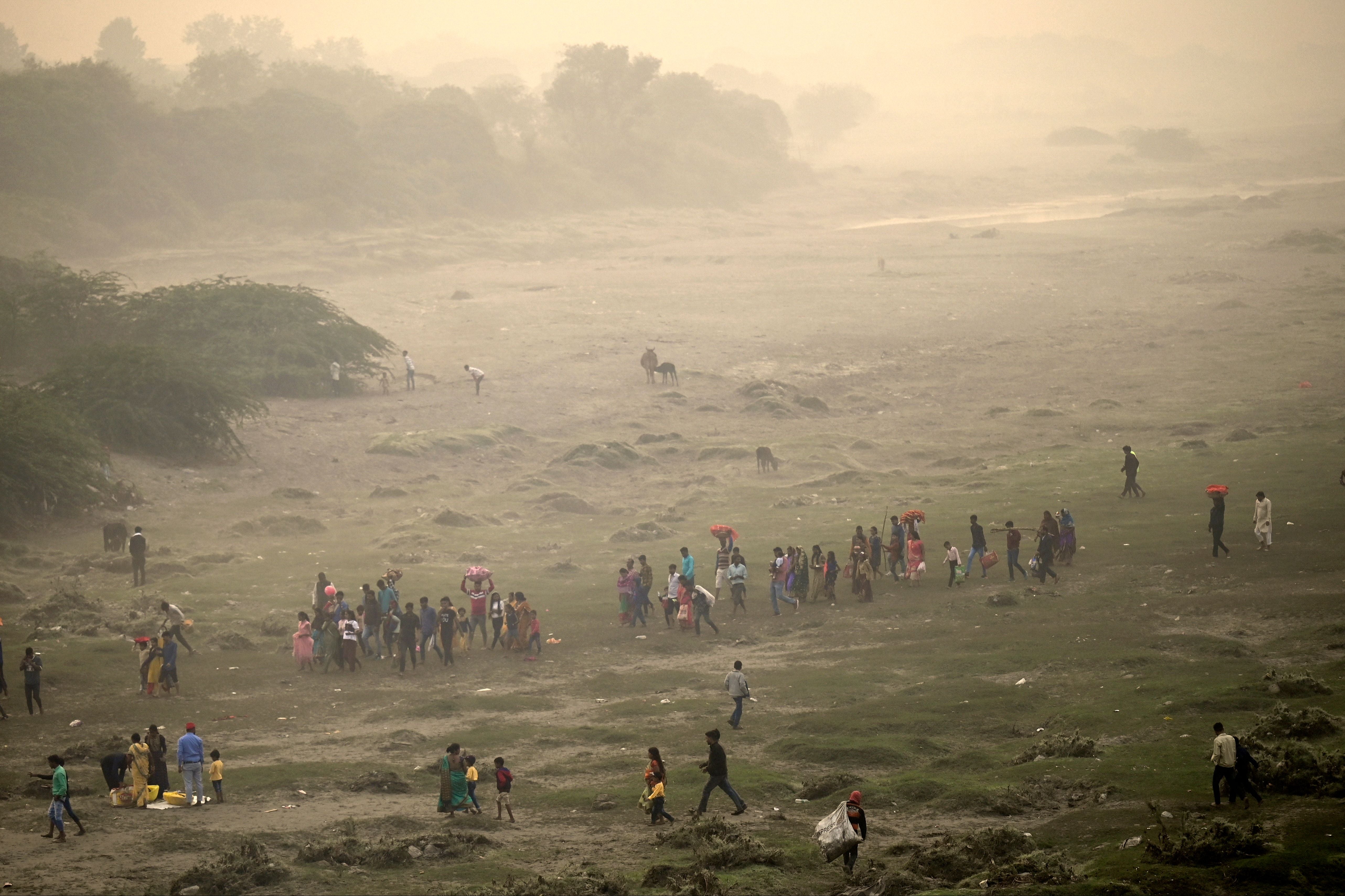 Devotees walk back after taking part in rituals to worship the sun on the banks of river Yamuna during the Hindu festival of Chhath Puja on the outskirts of New Delhi on Monday