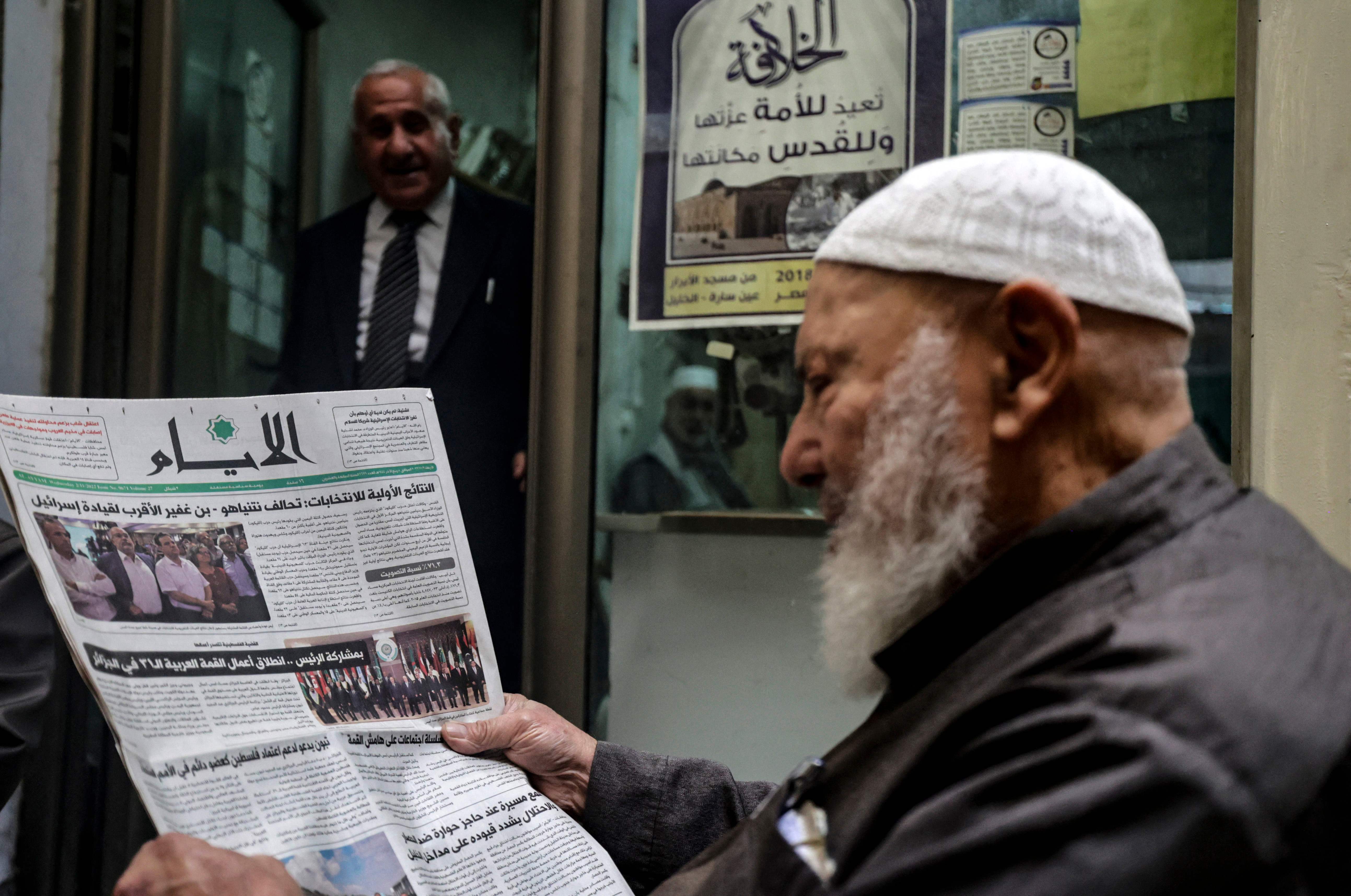 A Palestinian man reads the headlines of a local newspaper in the occupied-West Bank city of Hebron