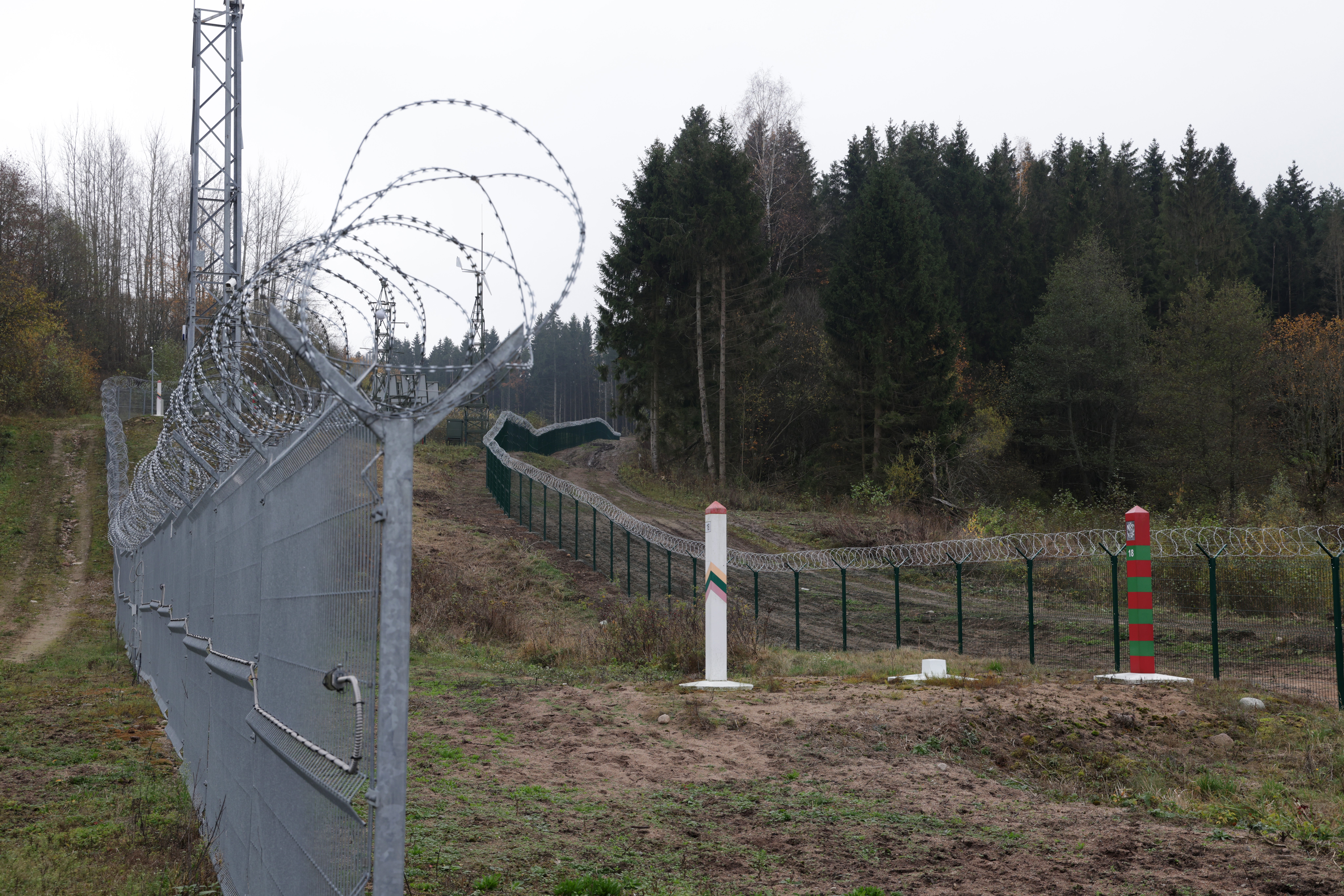 A Lithuanian border fence and marker face a Russian border marker at the Russian semi-exclave of Kaliningrad