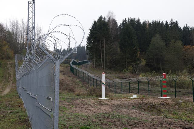 <p>A Lithuanian border fence and marker face a Russian border marker at the Russian semi-exclave of Kaliningrad</p>