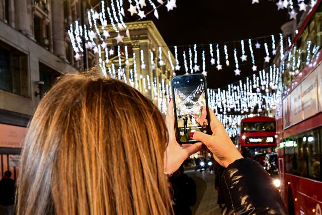 A member of the public takes a photo at the Oxford Street Christmas lights switch-on (Matt Crossick/PA)