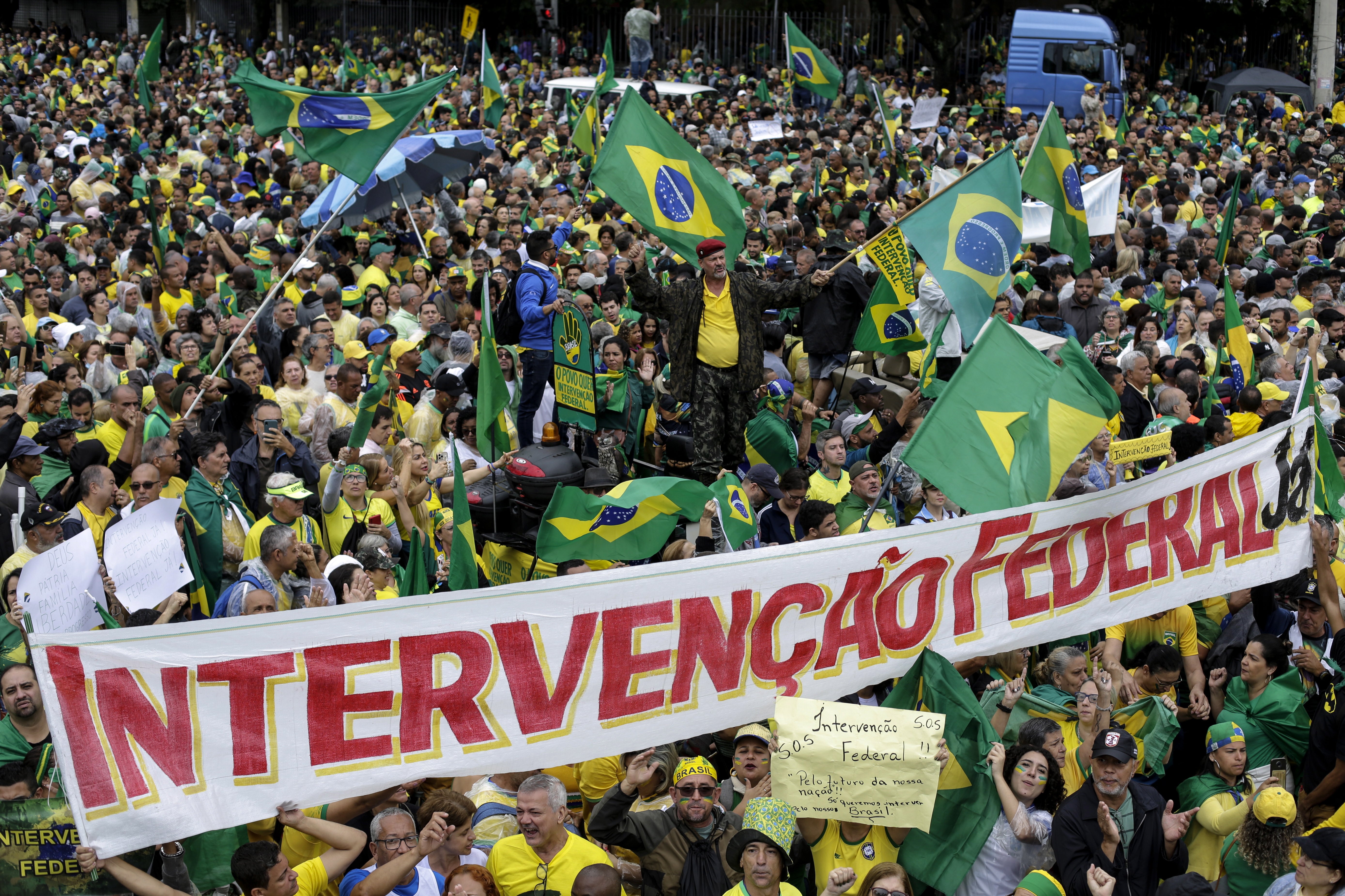 Supporters of outgoing Brazilian President Jair Bolsonaro hold a banner reading ‘Federal intervention’ during protest against the election results outside the Eastern Military Command in Rio de Janeiro