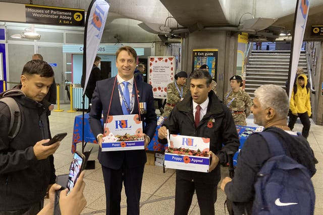 Handout photo taken with permission from the Twitter account @sara_le_roux of Prime Minister Rishi Sunak selling poppies for the Royal British Legion Poppy Appeal 2022, at Westminster Tube station in central London (@sara_le_roux/PA)