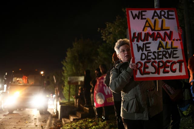 <p>A woman holds a sign during a vigil calling for the Manston immigration processing centre to be closed</p>