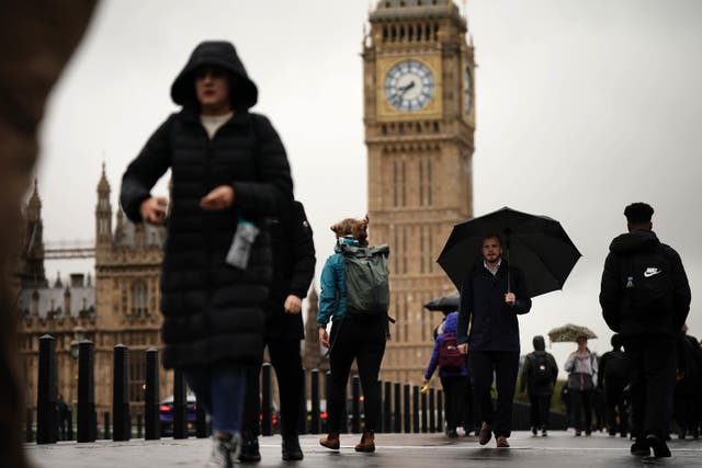 Commuters with umbrellas in Westminster in London (Aaron Chown/PA)