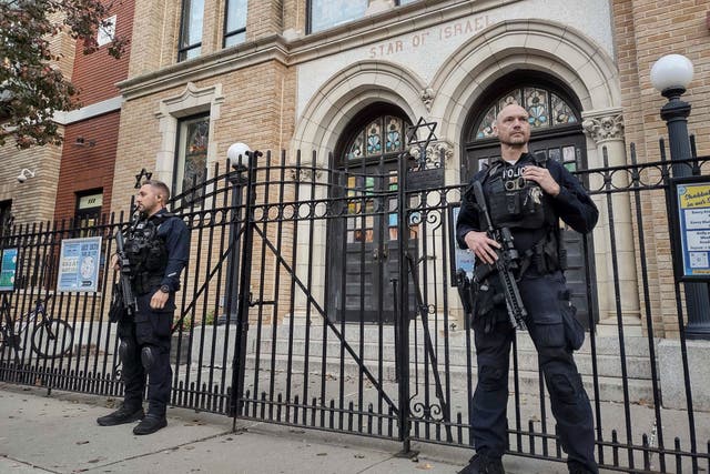 <p>Hoboken Police officers stand watch outside the United Synagogue of Hoboken in New Jersey on Thursday</p>