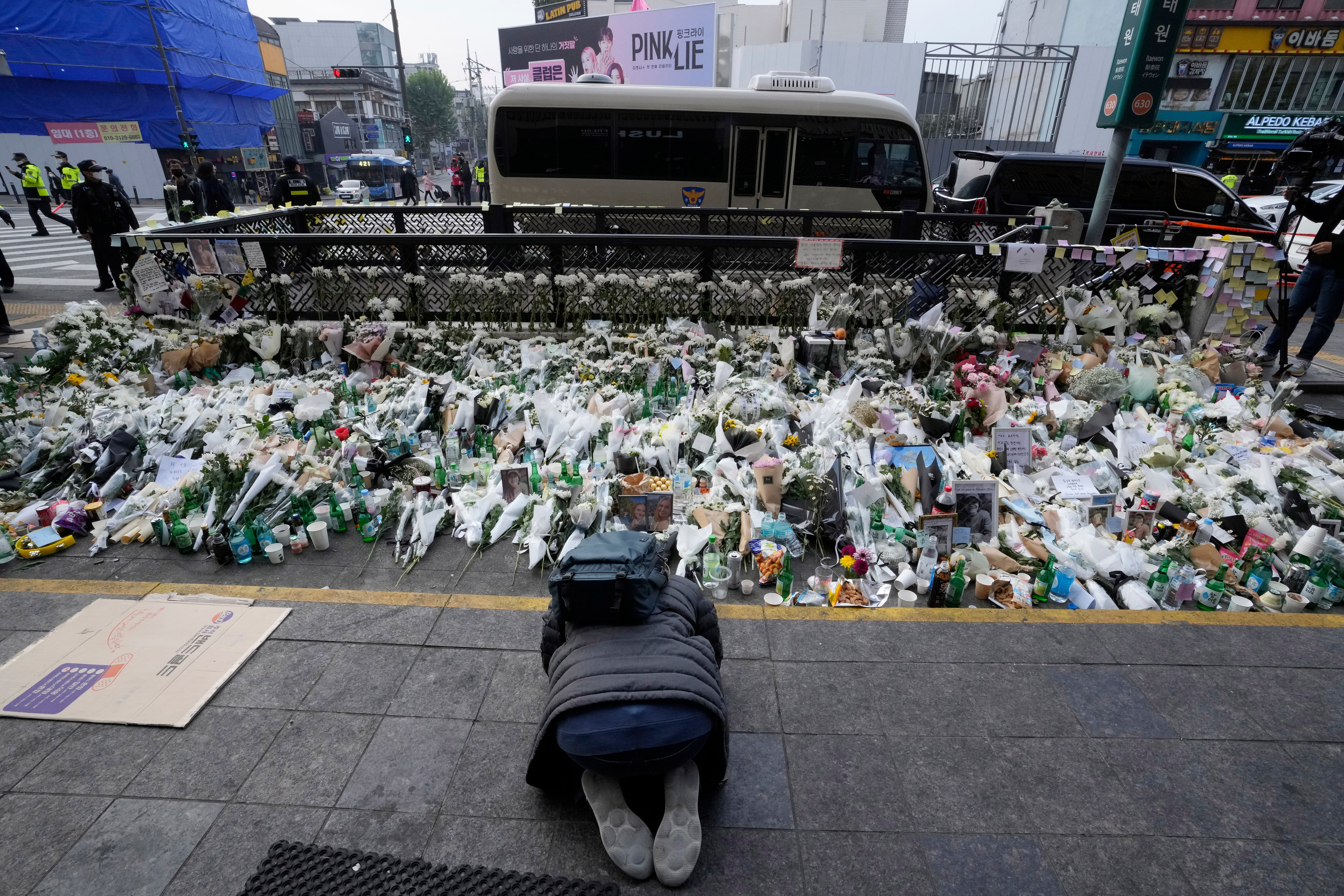 A man bows to pay tribute to victims of a deadly accident that happened during Saturday night's Halloween festivities, on a street near the scene in Seoul, South Korea, Tuesday, 1 November 2022