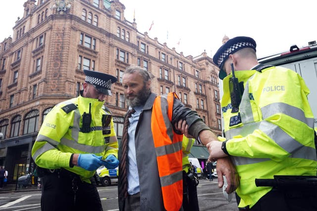 Police officers deal with activists from Just Stop Oil during their protest outside Harrods department store (PA)