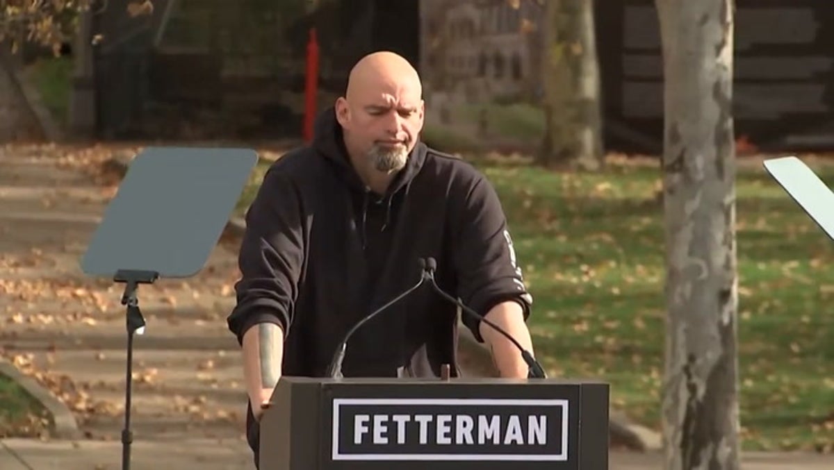 Strong winds blow down American flags behind John Fetterman at Obama rally