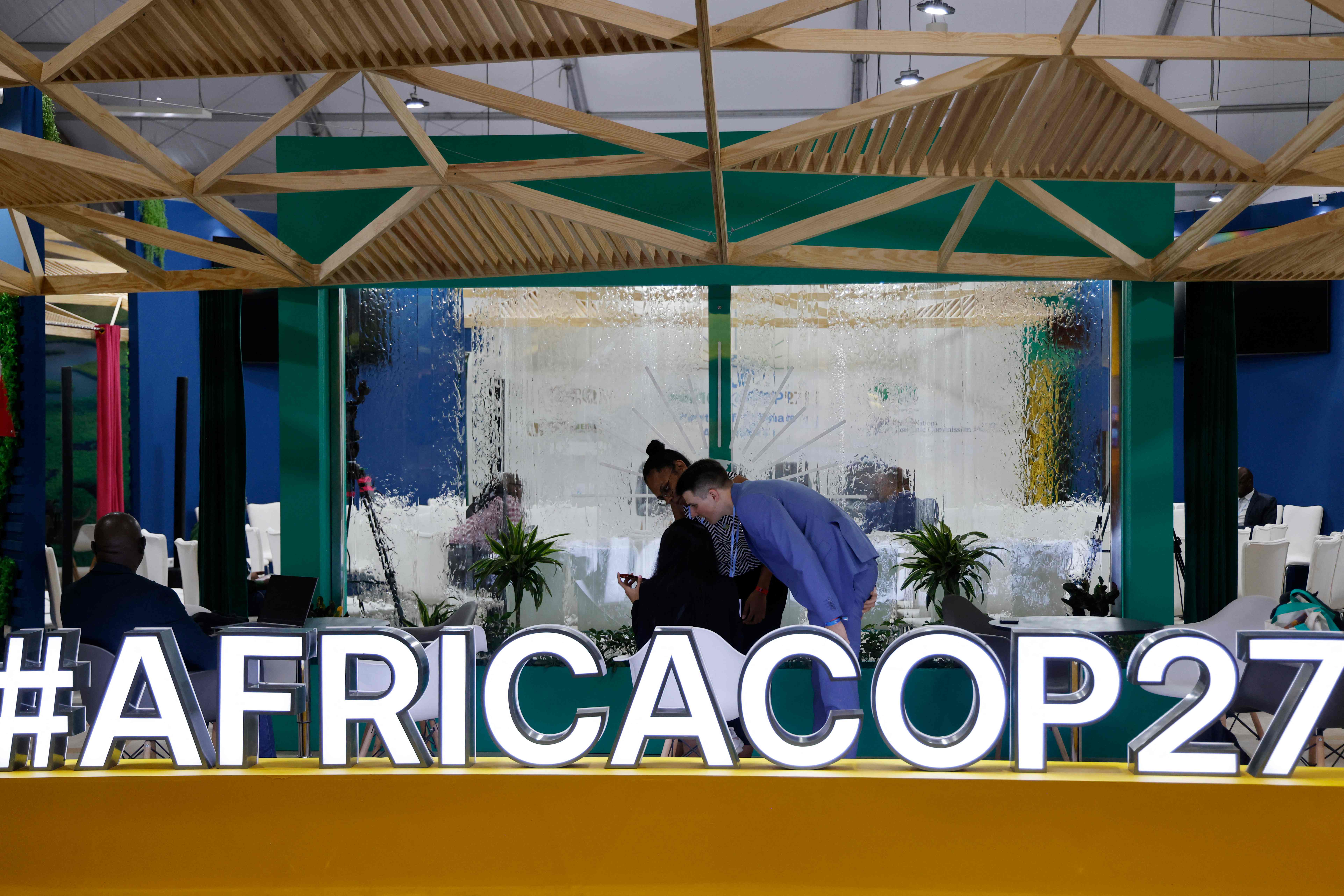 Participants and delegates work in the Africa pavilion at the Sharm El Sheikh International Convention Centre