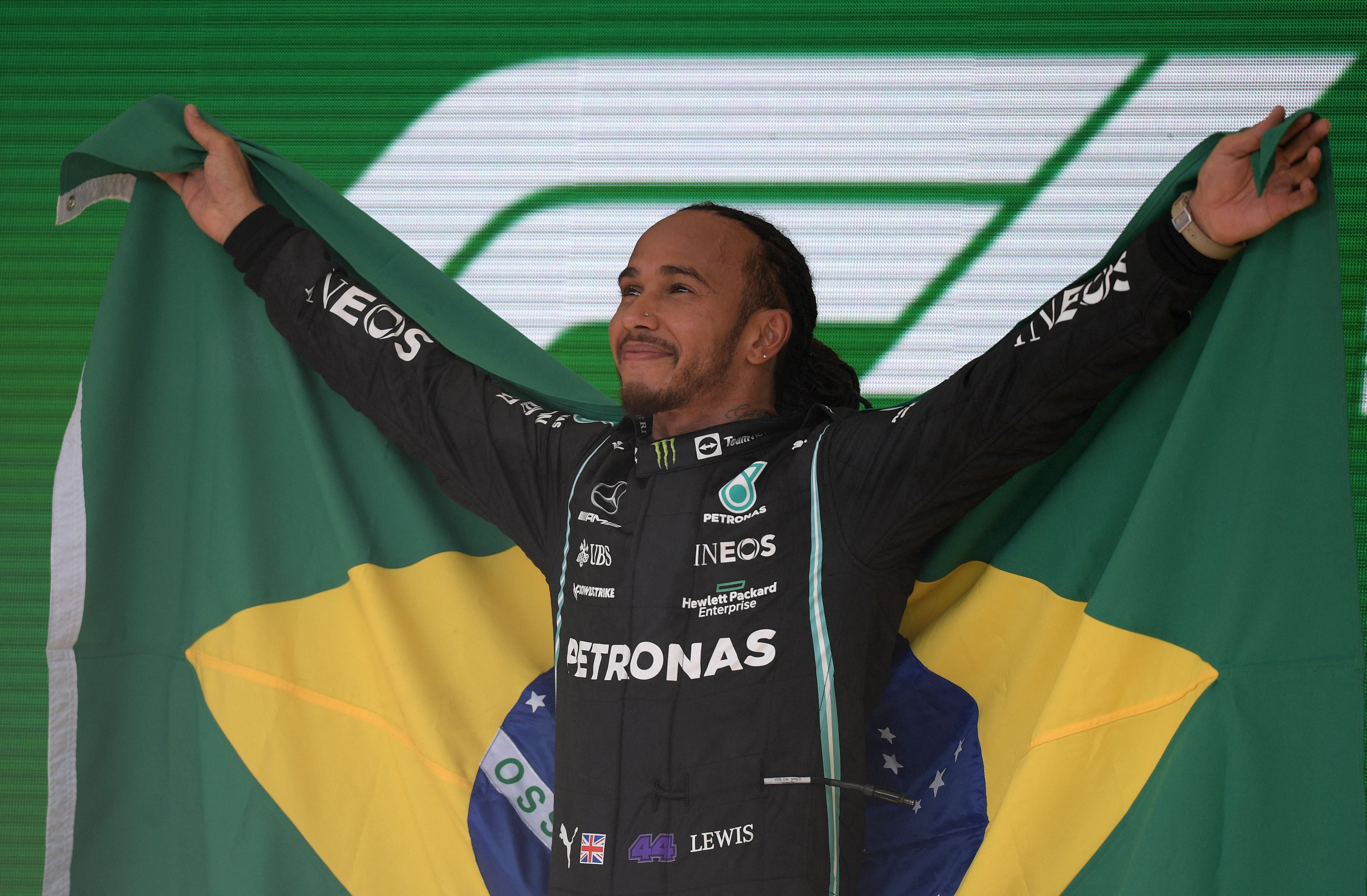Hamilton lifts the Brazil flag after his triumph at Interlagos last year